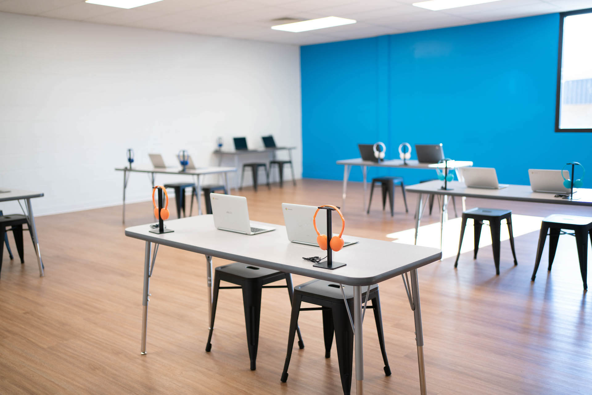 grey and blue classroom with laptops