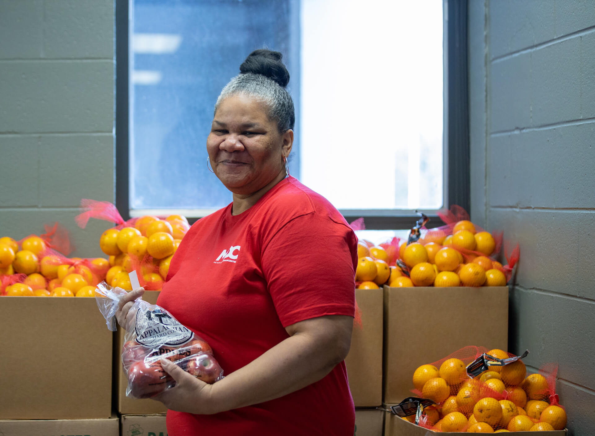 smiling volunteer serving fruit at food pantry