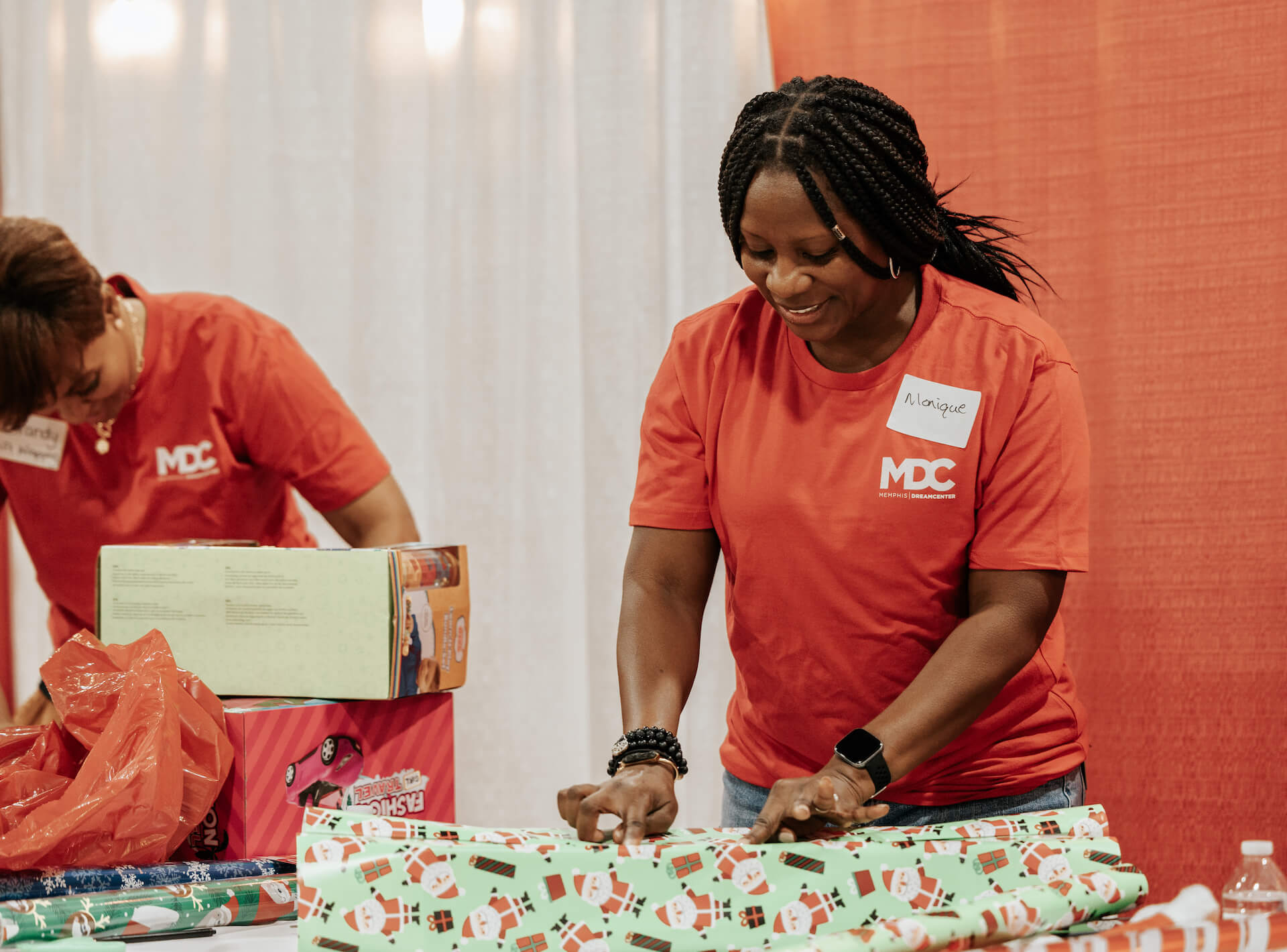 smiling volunteer wrapping Christmas presents