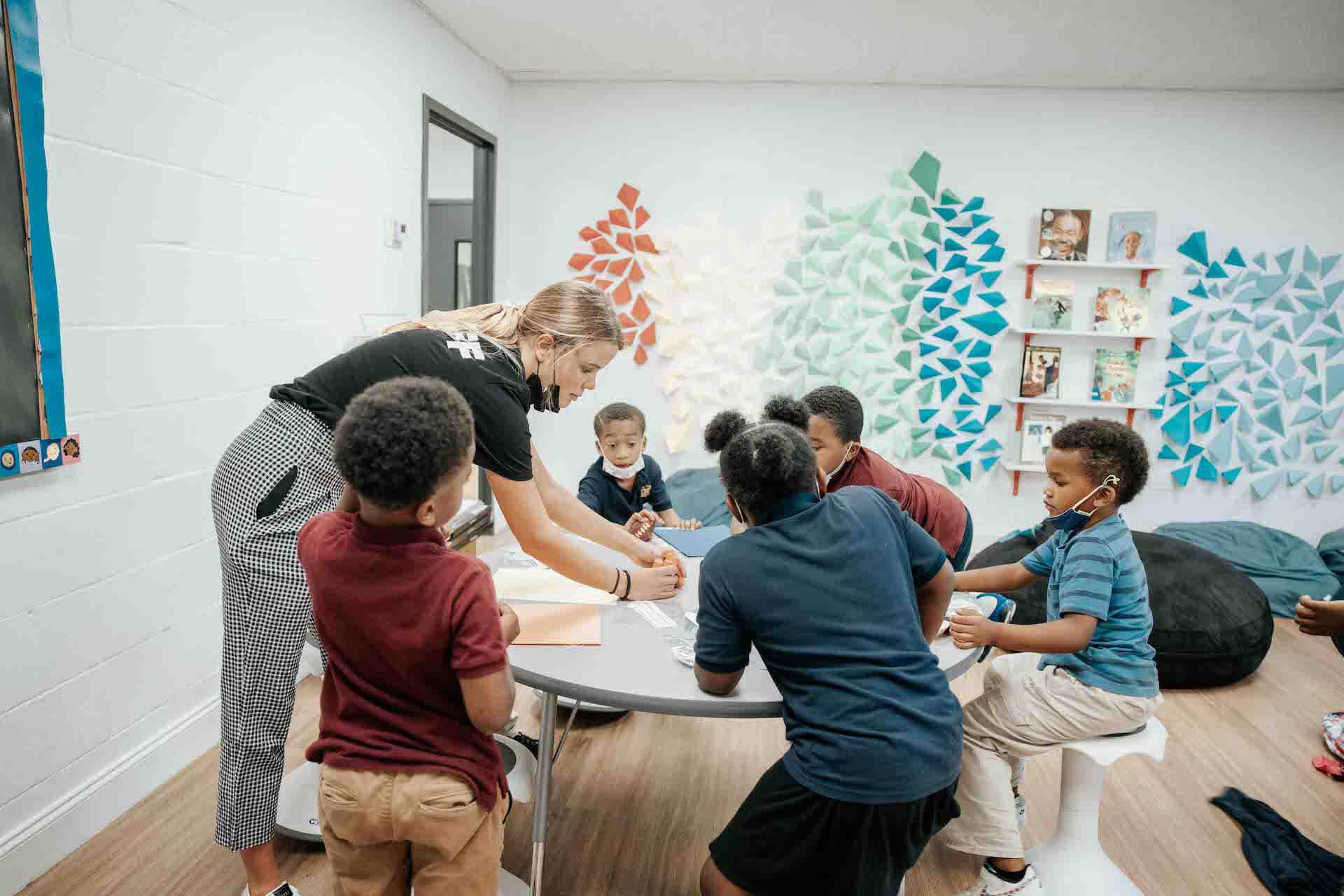 volunteer teaching kids around round table